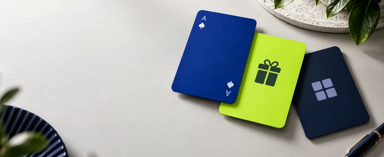 Blue ace card, lime gift card and navy grid card on a light tabletop